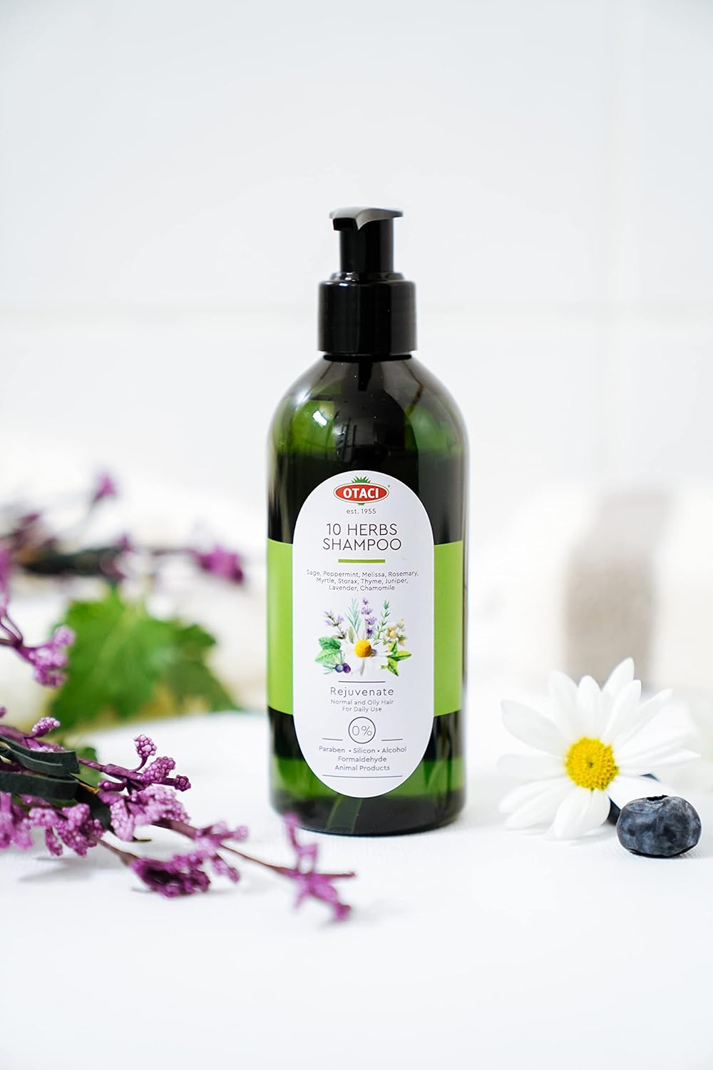 A visual of Otaci 10 Herbs Shampoo rejuvenating natural ingredients. Next to lavender on a white desk.