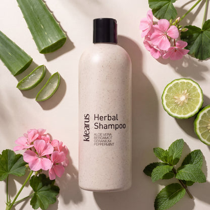 Klearus Frizz Control herbal shampoo flat-lay with aloe vera, halved bergamot, geranium and peppermint